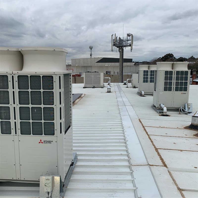 Large commercial outdoor air conditioning units on a flat metal roof